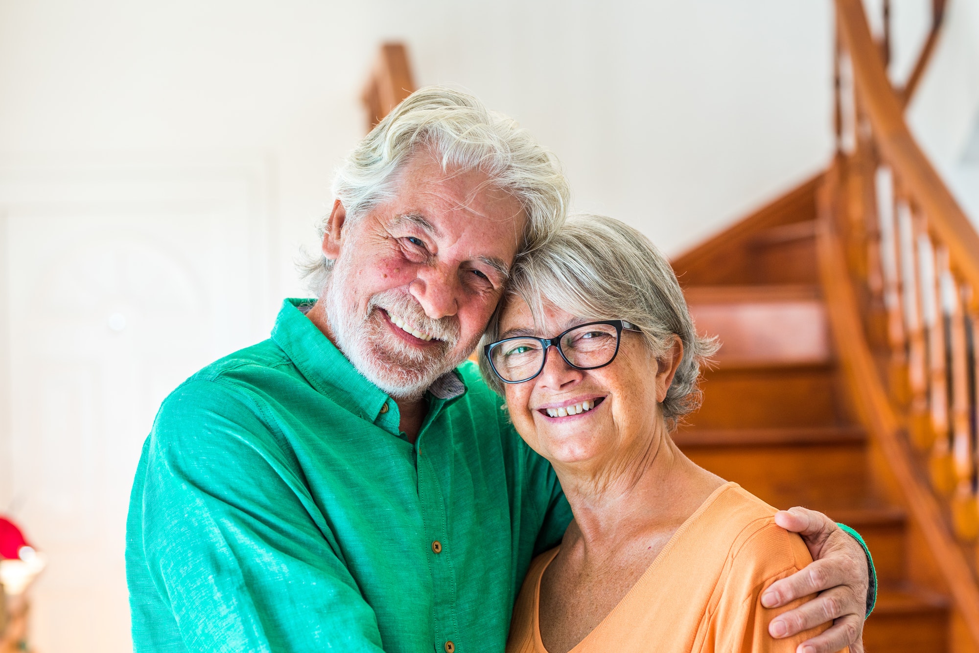 portrait and close up of two happy seniors or mature and old people smiling and looking the camera